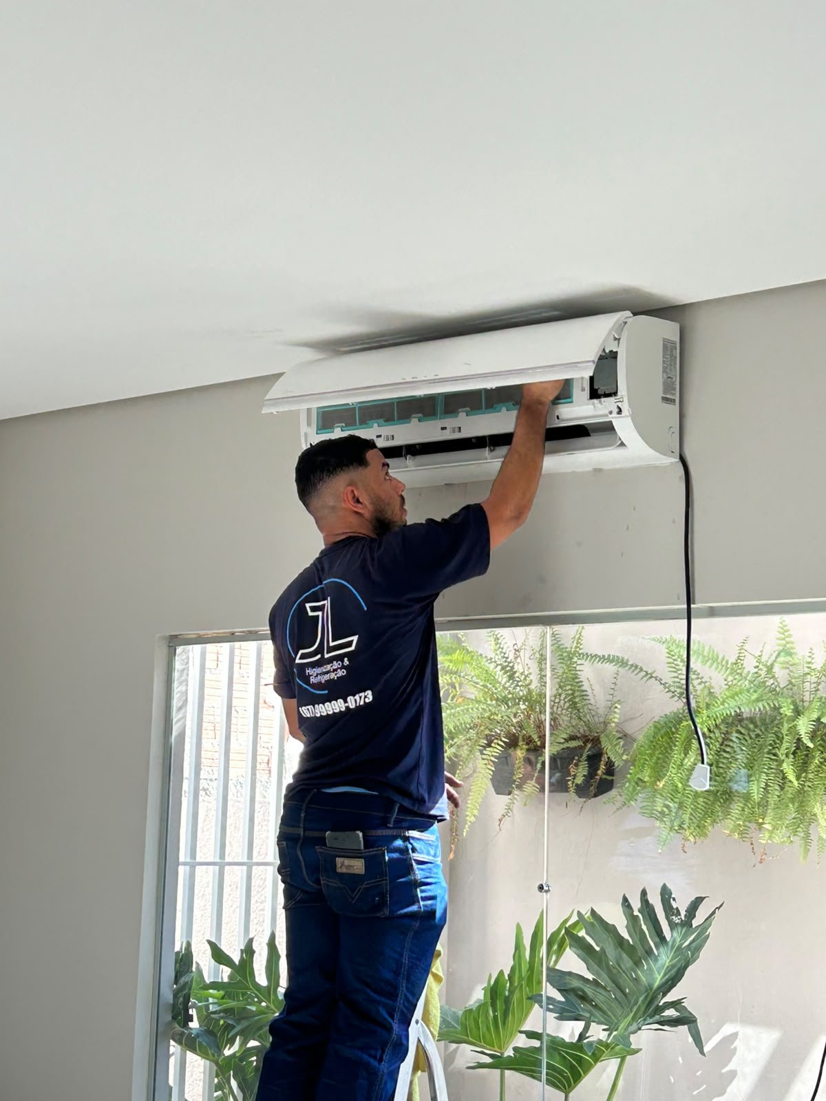 Técnico da JL realizando higienização de ar-condicionado split em residência